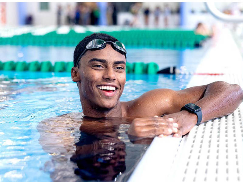 Tulane student Mekonnen Sahle-Selassie smiles while stopping to catch his breath, while swimming laps in the natatorium. Photo by Sabree Hill.