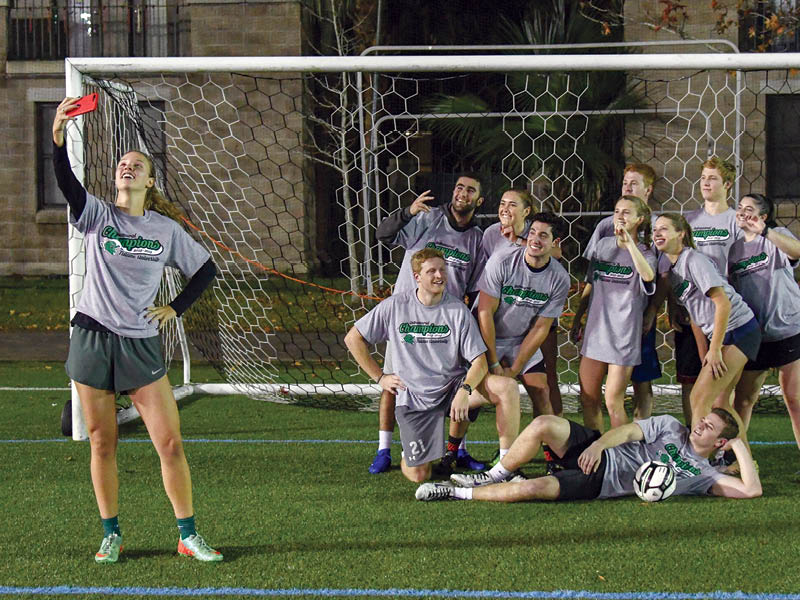 Winning soccer team taking a selfie with Intramural Sports Champion tees.