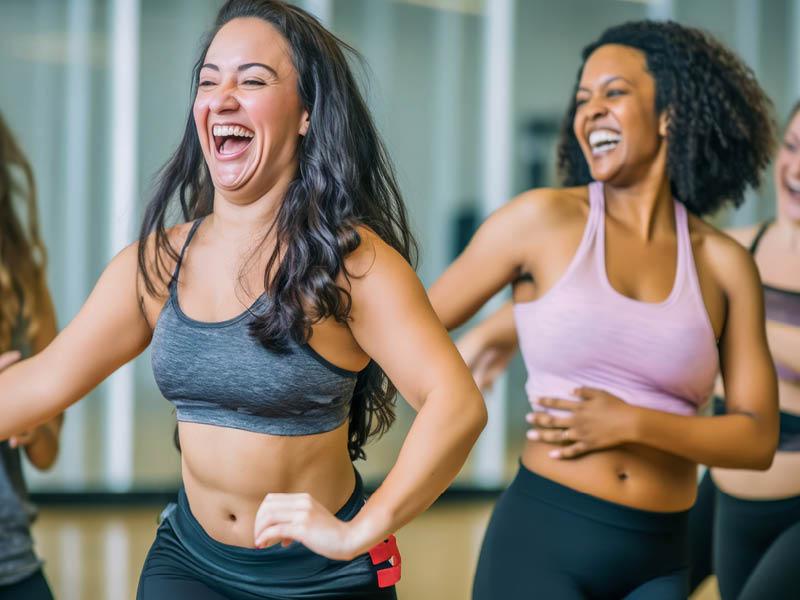 5 Tips for National Women’s Health and Fitness Day Women enjoying a joyful dance class, candidly expressing their active lifestyle through Zumba with friends