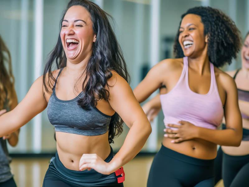 Women enjoying a joyful dance class, candidly expressing their active lifestyle through Zumba with friends