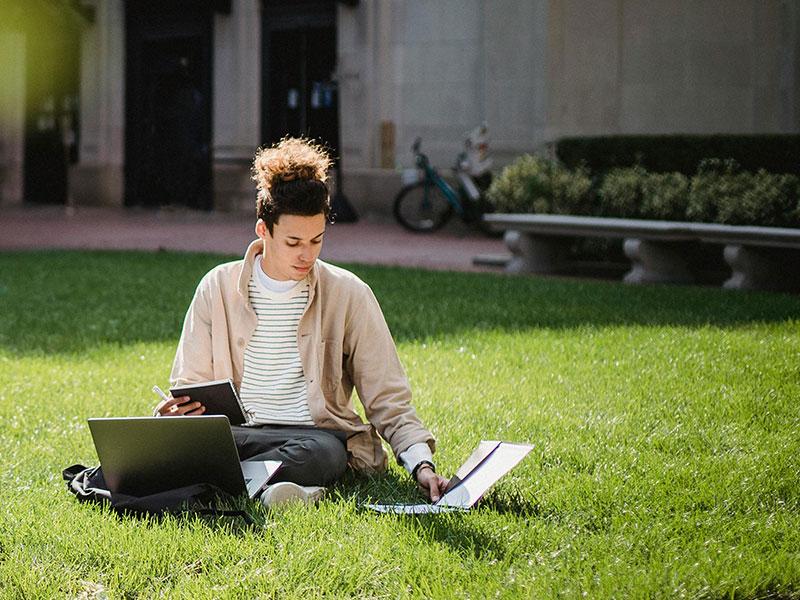 Young man studying outside on a quad Young man studying outside on a quad