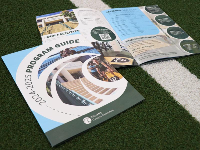 Two copies of the 2024-2025 Program Guide on turf.